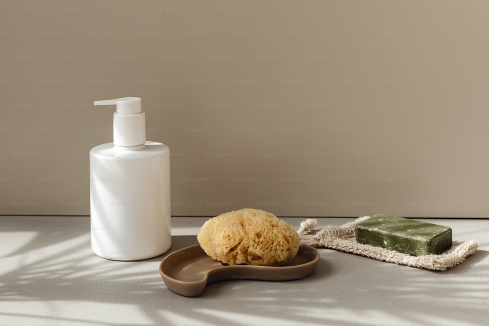 a soap dispenser, soap bar, and sponge sit on a counter