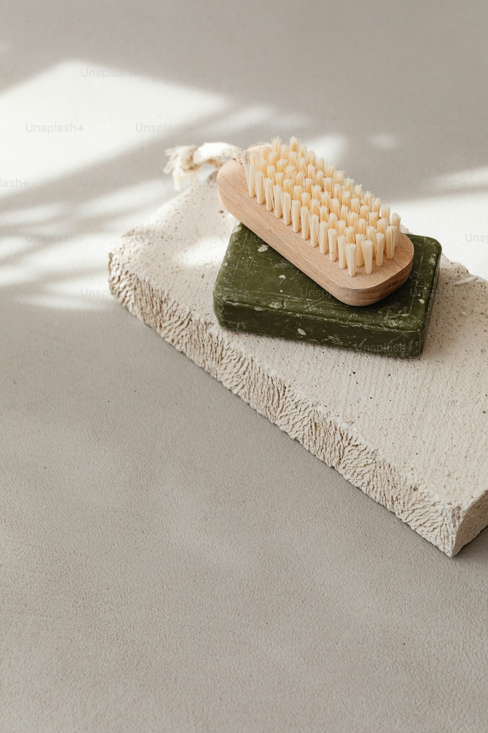 a white and green brush sitting on top of a stone