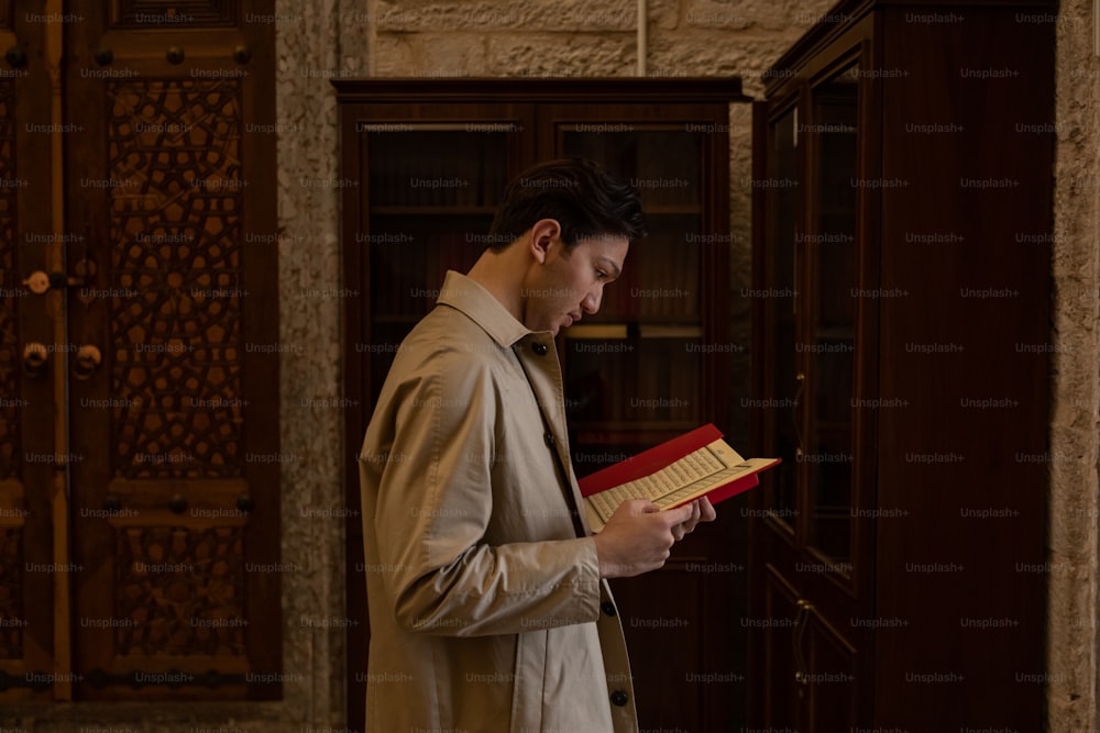 a man standing in a room reading a book
