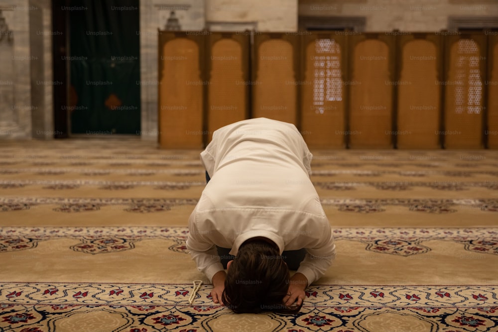 a person kneeling down on a rug in a room