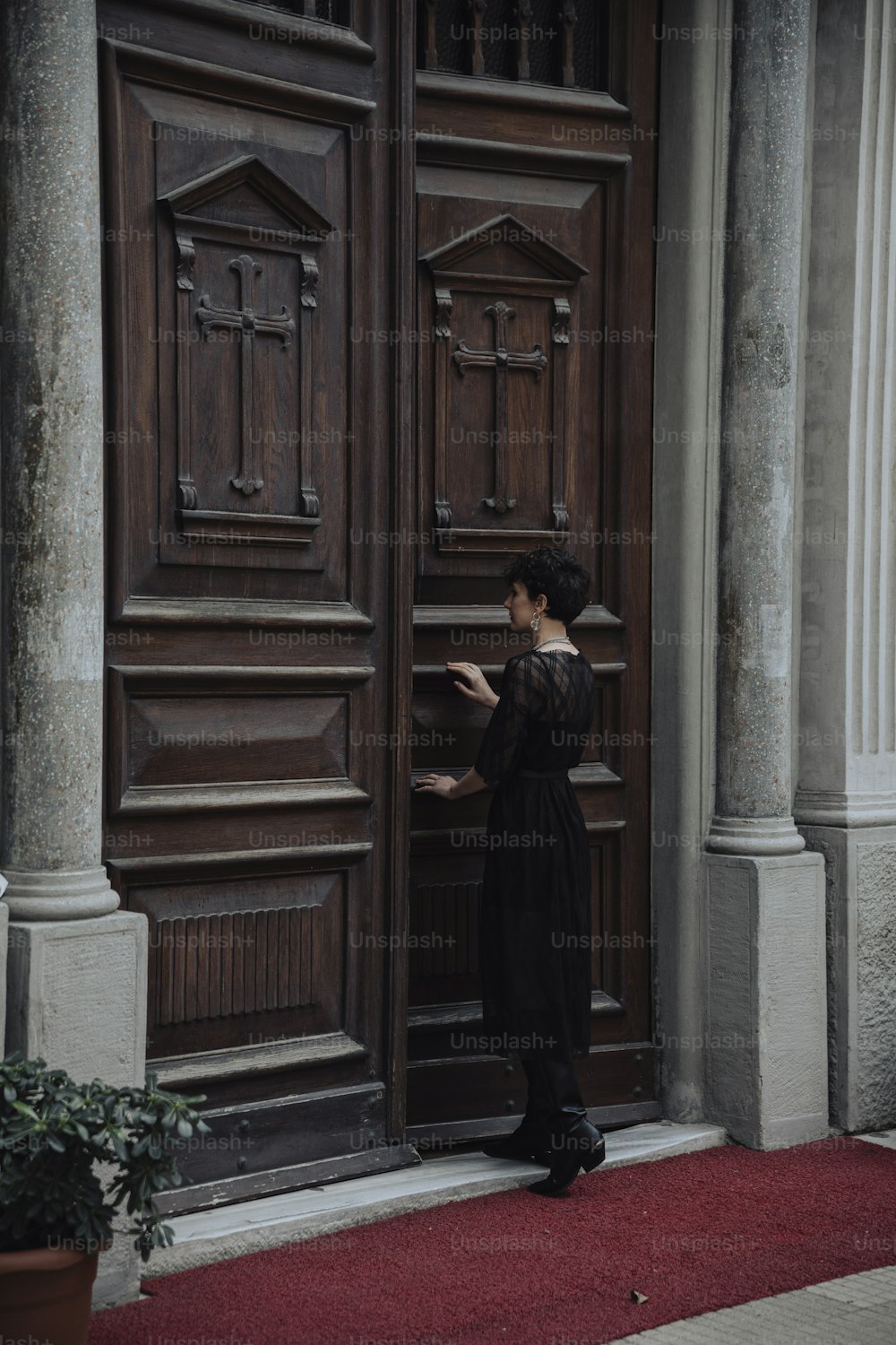 uma mulher em pé na frente de uma porta de madeira