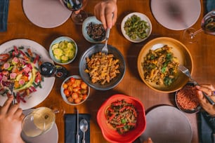a group of people sitting at a table with plates of food