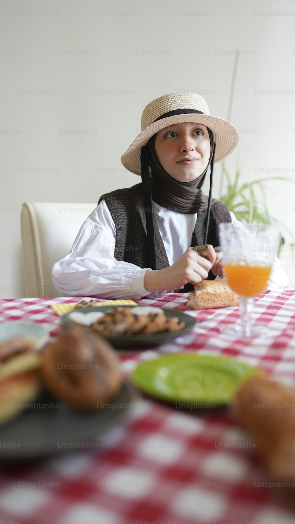 a woman wearing a hat sitting at a table