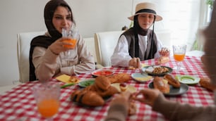 a couple of women sitting at a table with plates of food