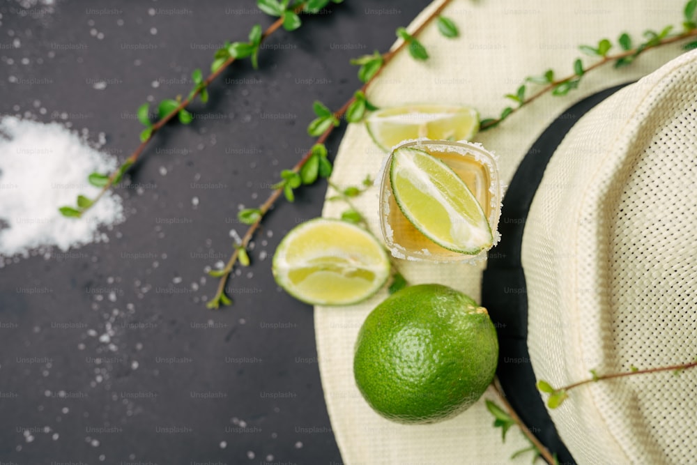 a hat and two limes on a table