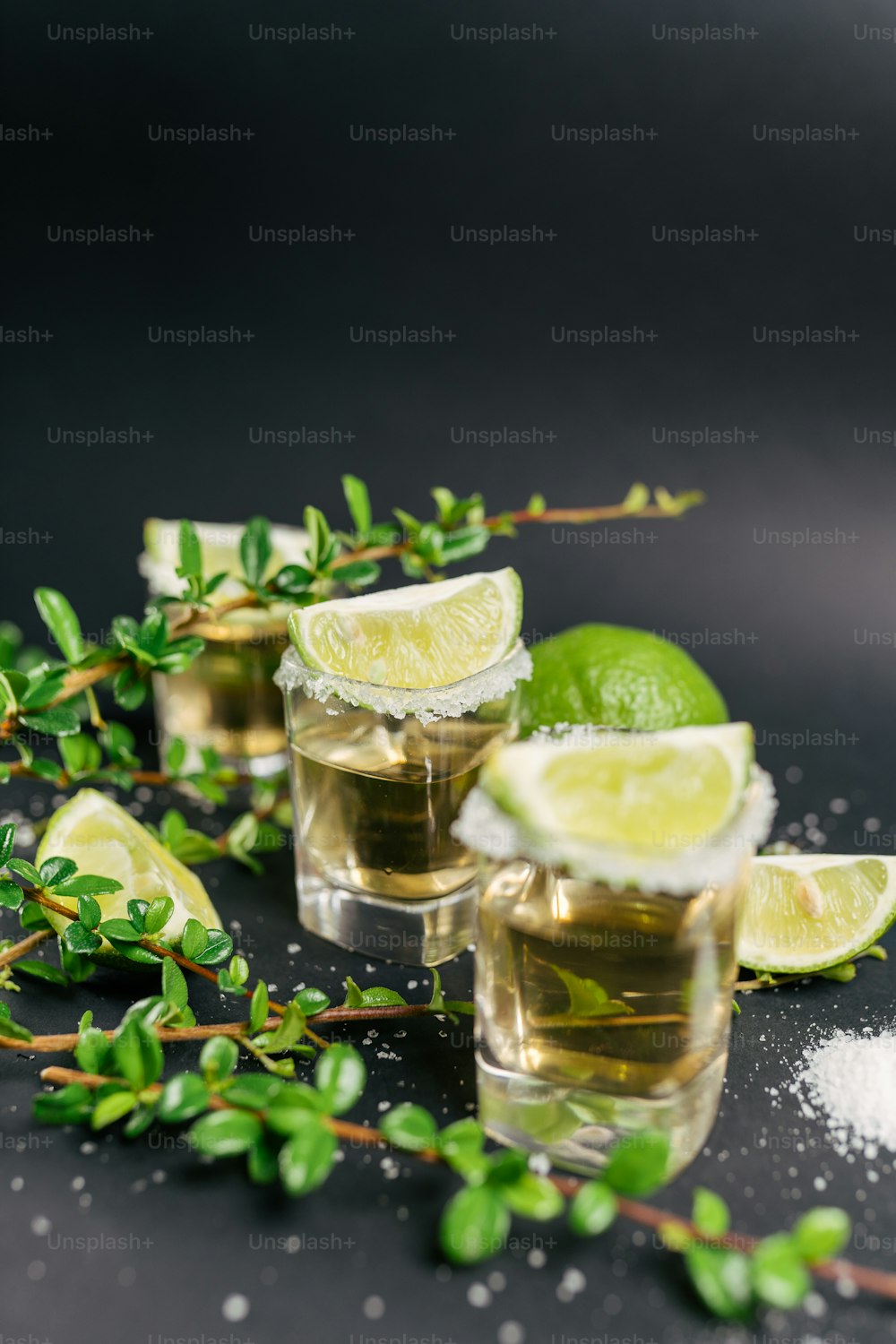 a couple of glasses filled with liquid and limes