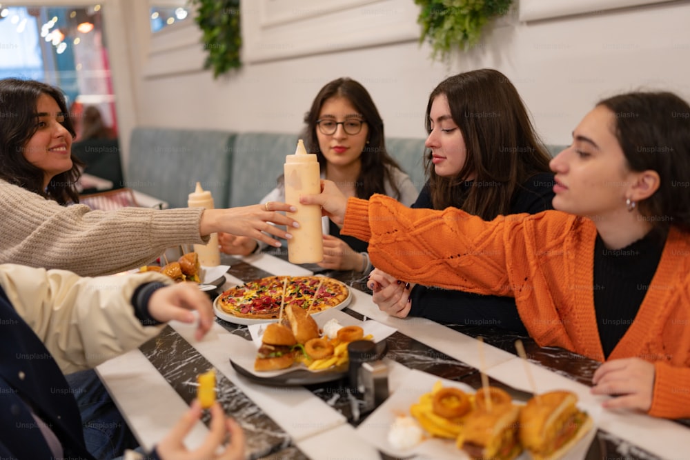 Un gruppo di donne sedute intorno a un tavolo che mangiano cibo