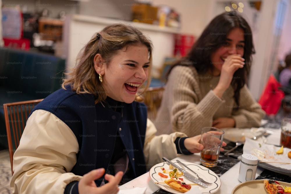 Un couple de femmes assises à une table avec des assiettes de nourriture