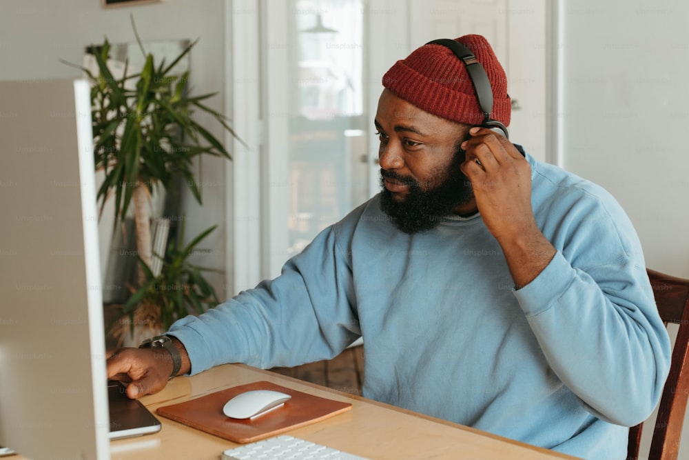 a man sitting at a desk talking on a cell phone