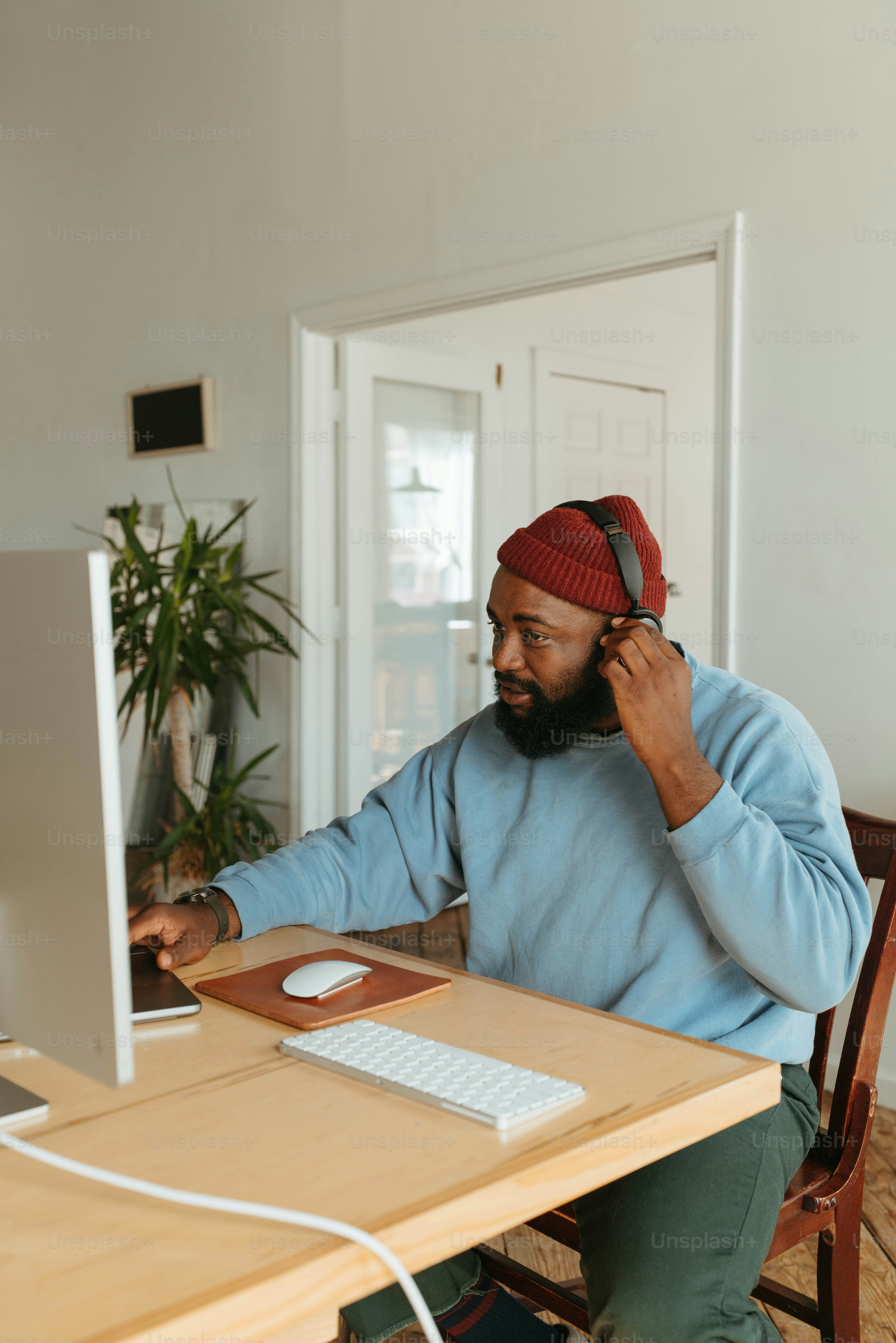 um homem sentado em uma mesa falando em um telefone celular
