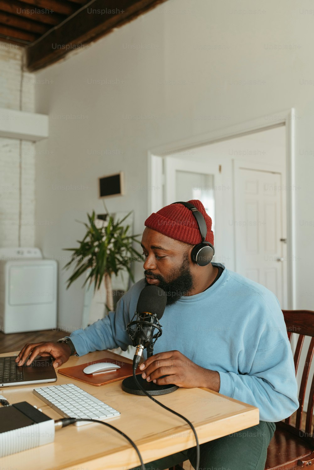 Un homme assis à une table avec un ordinateur portable et des écouteurs