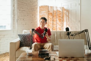 a man sitting on a couch holding a microphone