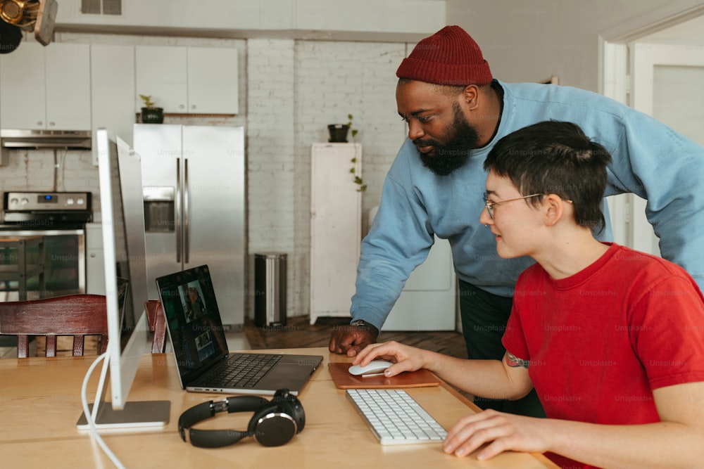 a man and a boy are looking at a laptop