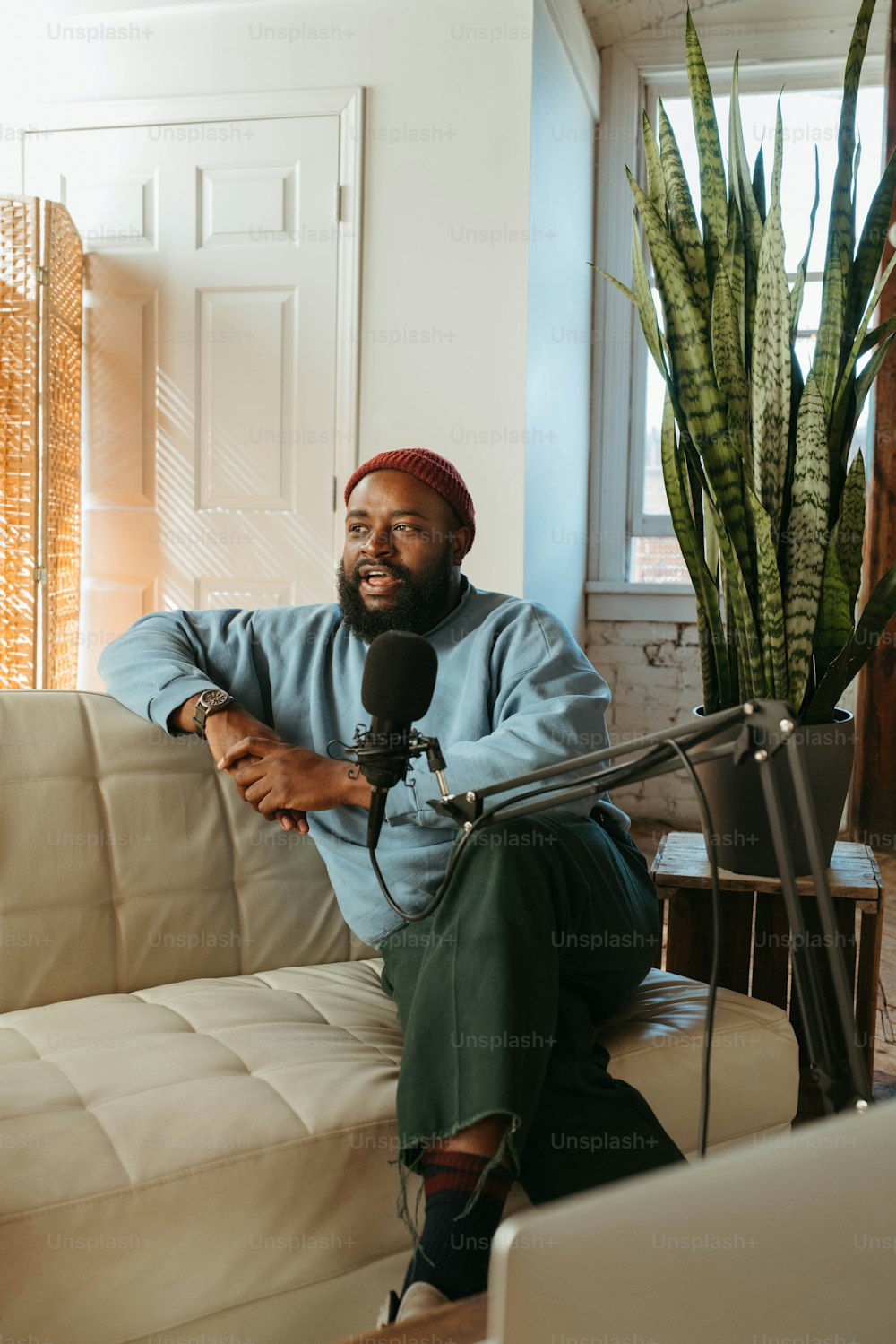 a man sitting on a couch with a microphone