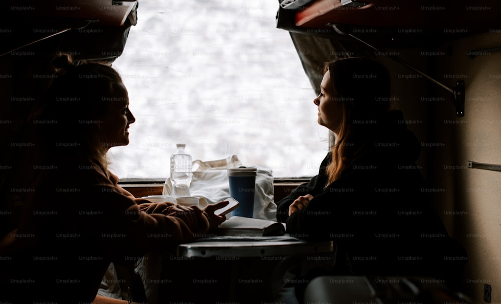 테이블에 나란히 앉아 있는 두 명의 여성