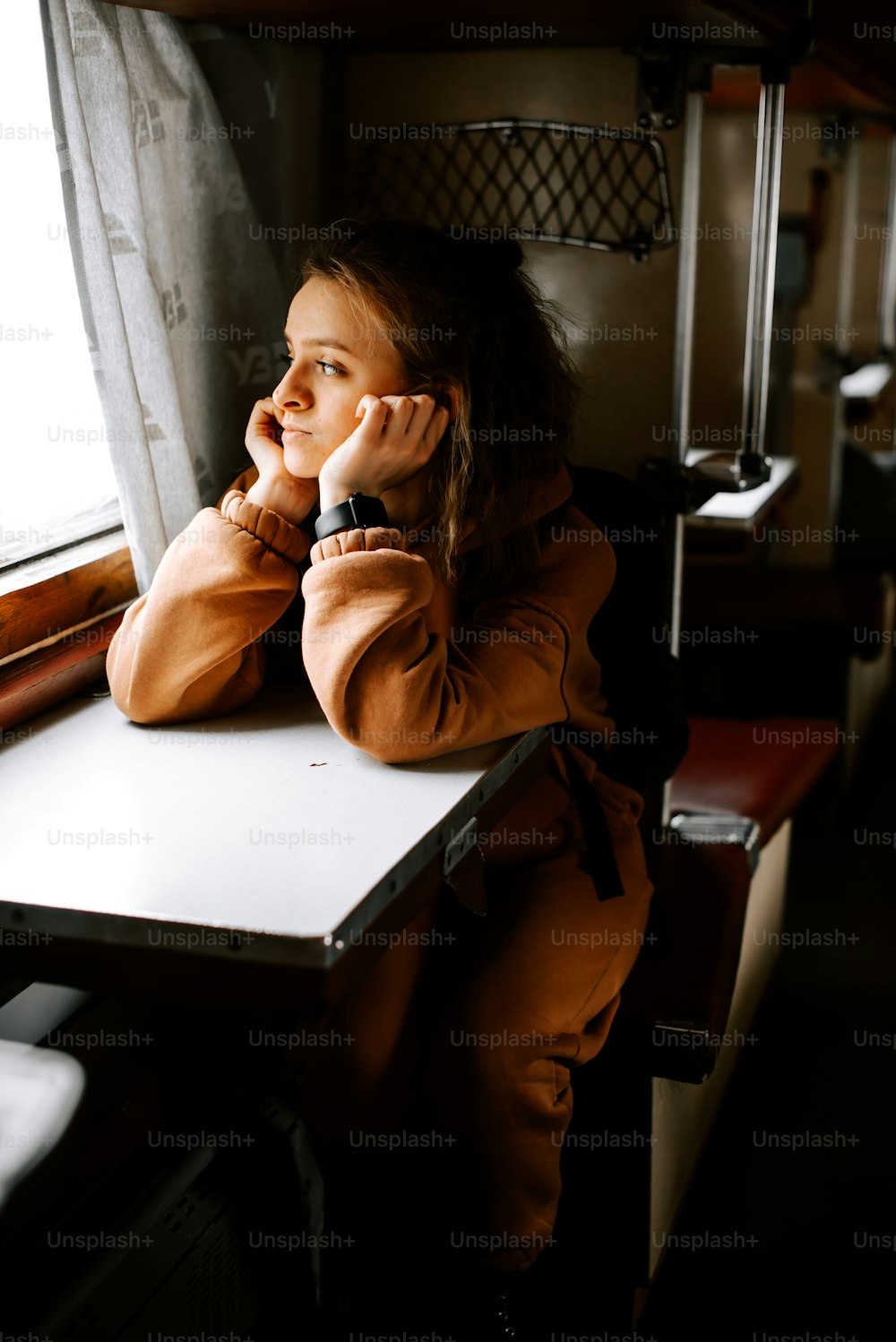 a woman sitting at a table talking on a cell phone