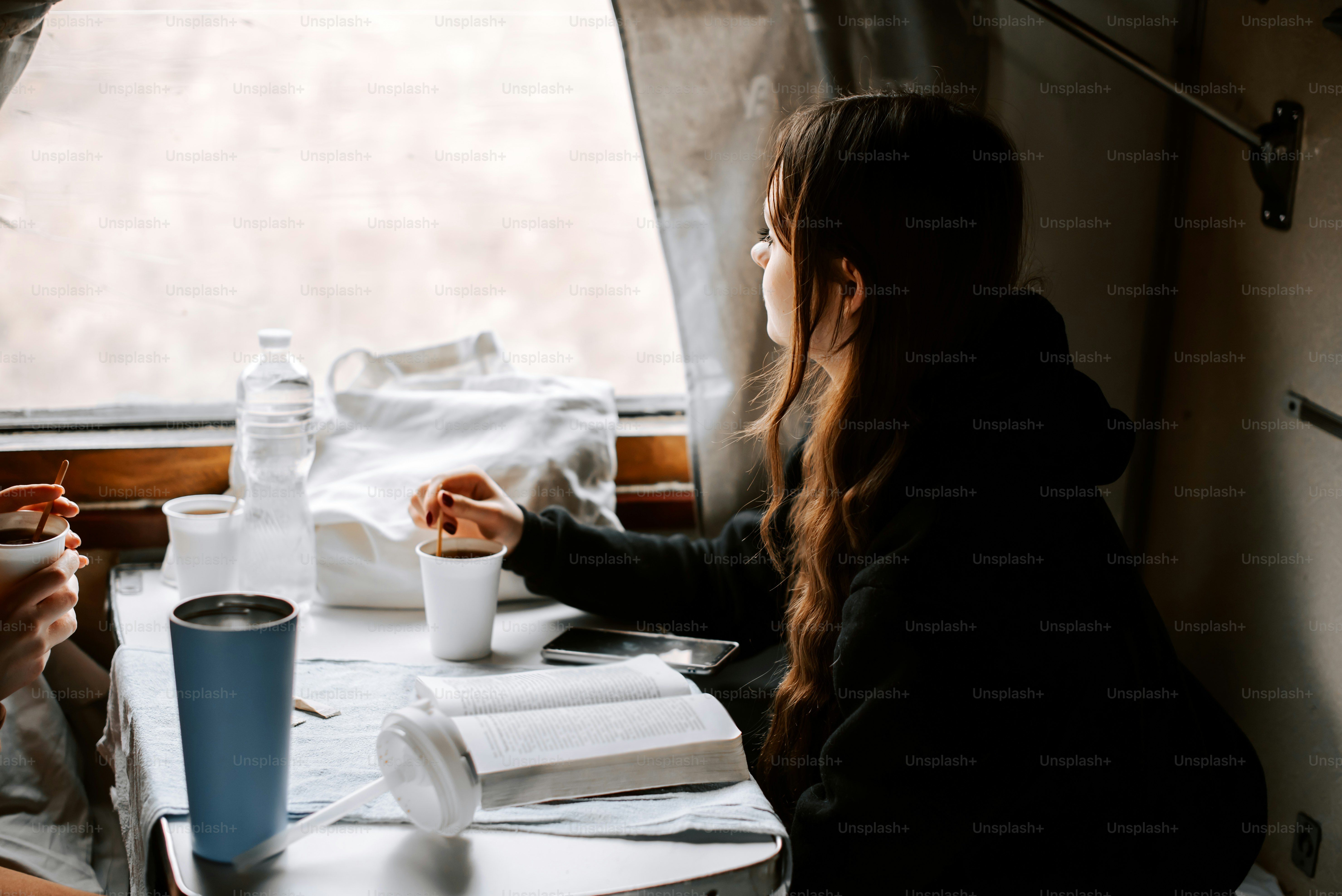 two women sitting at a table with cups of coffee