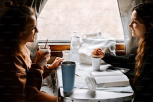 a couple of women sitting at a table next to each other