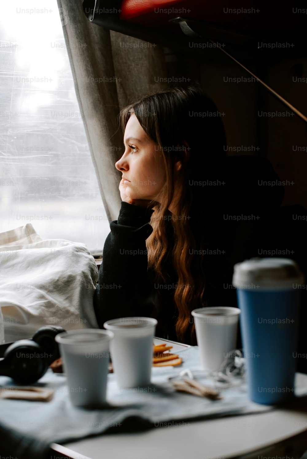 una donna seduta a un tavolo davanti a una finestra