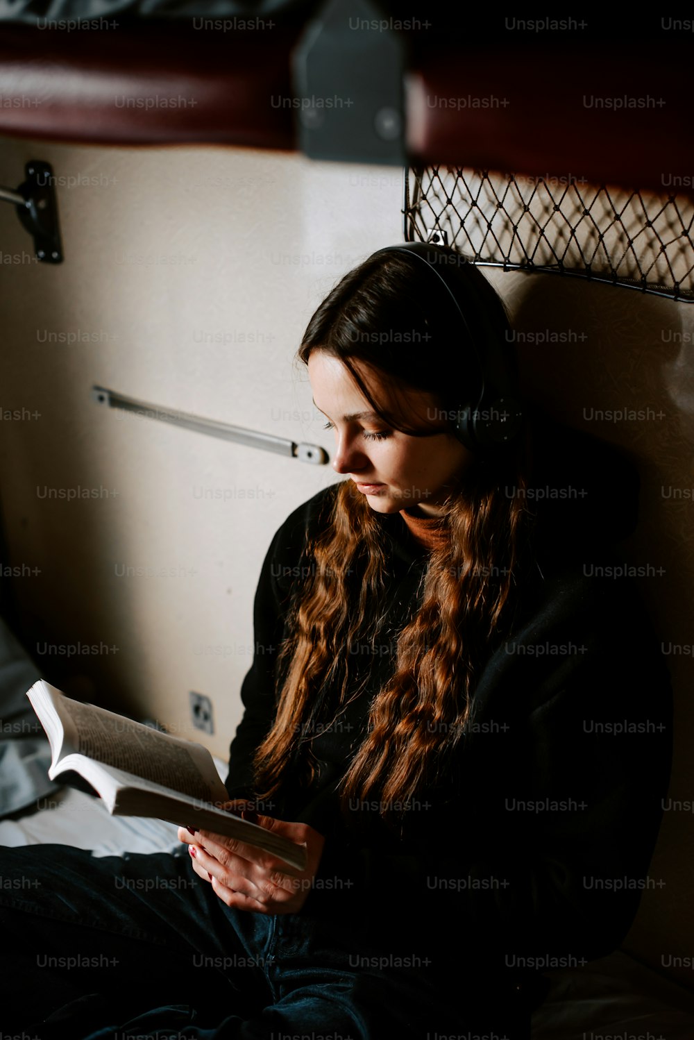 una donna seduta su un letto che legge un libro