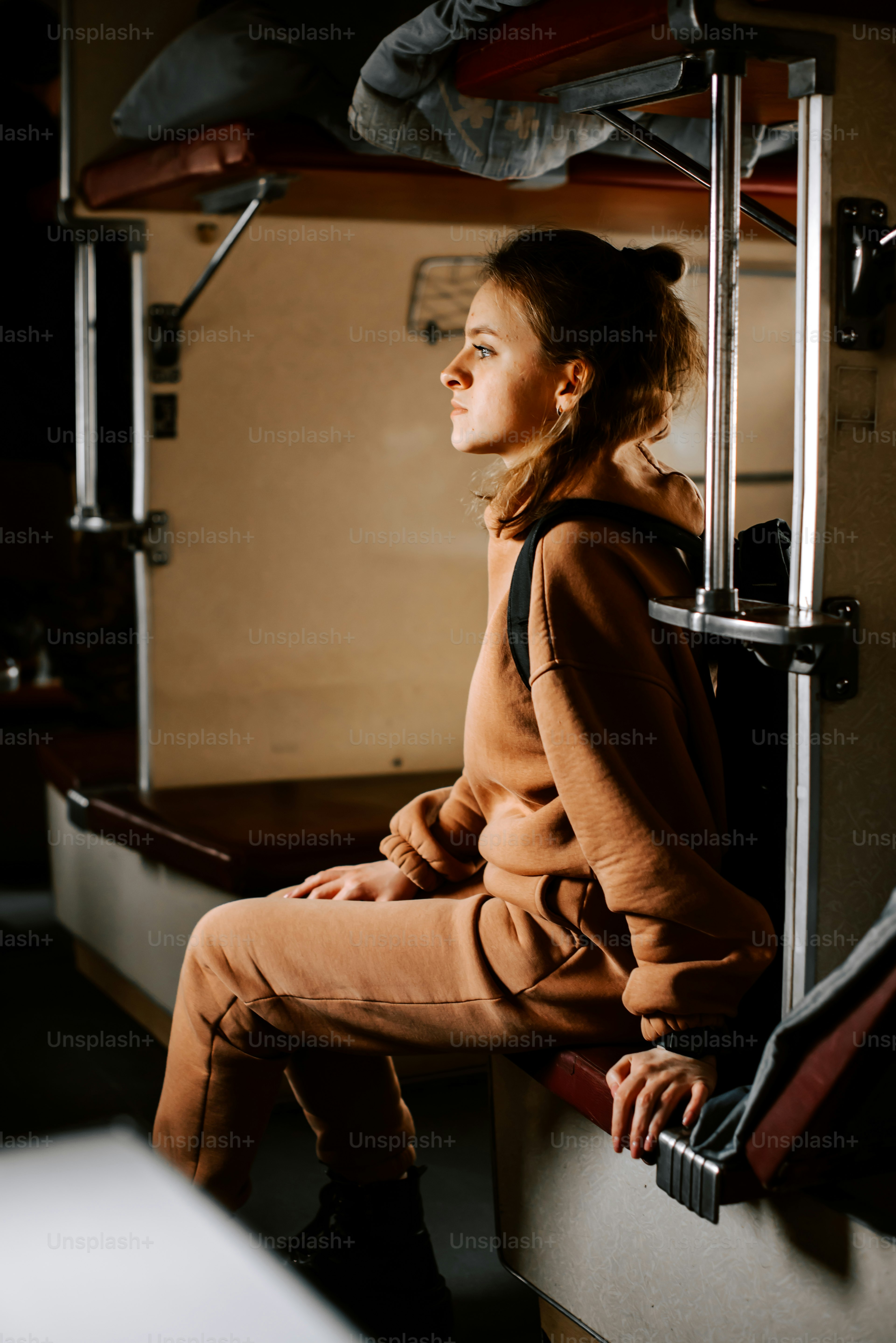 A young girl sitting on a bus looking out the window photo – Lone ...