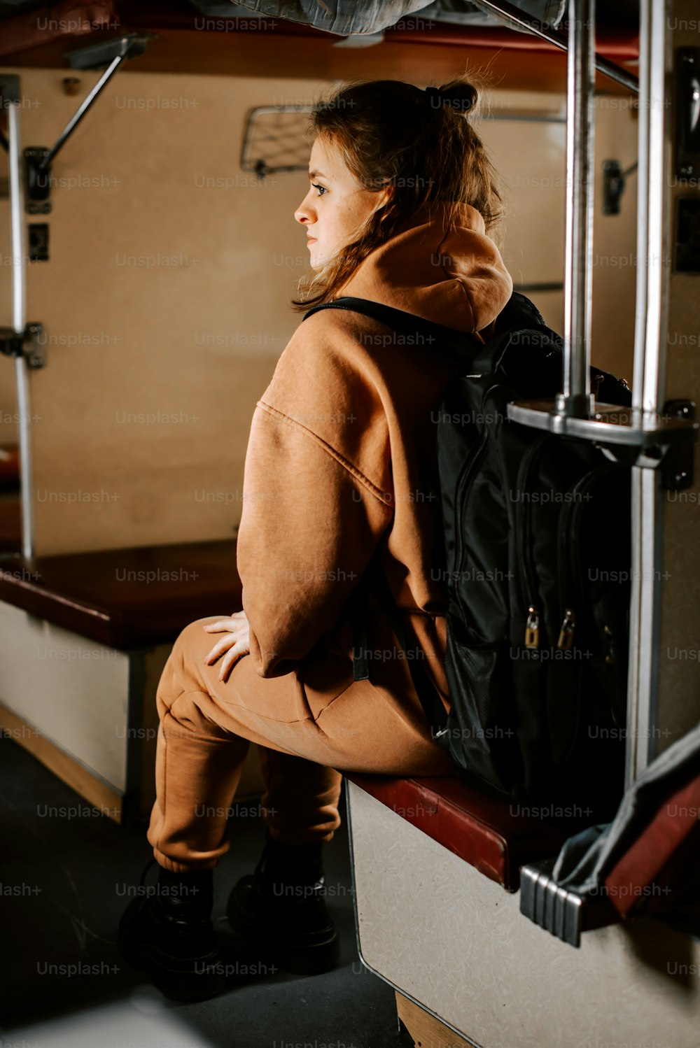 a girl sitting on a bench with a backpack