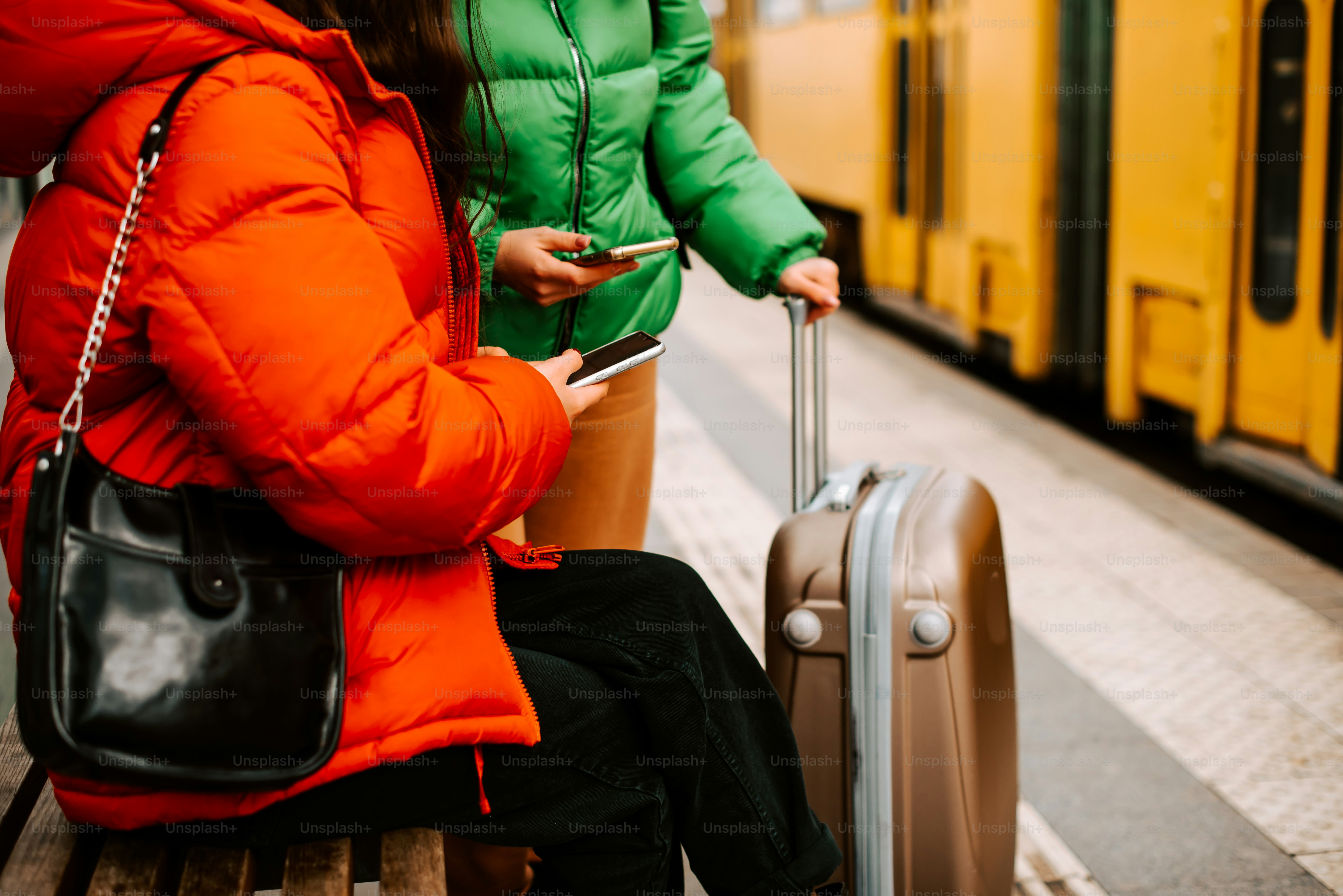 짐을 들고 벤치에 앉아 있는 두 여자