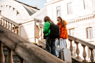 two women walking up a flight of stairs with luggage