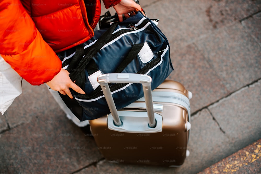 a person holding a suitcase and a handbag