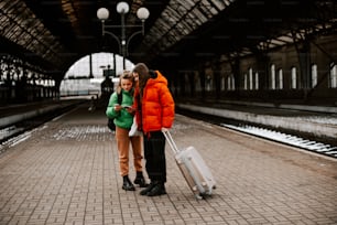 a man and a woman standing next to each other with luggage