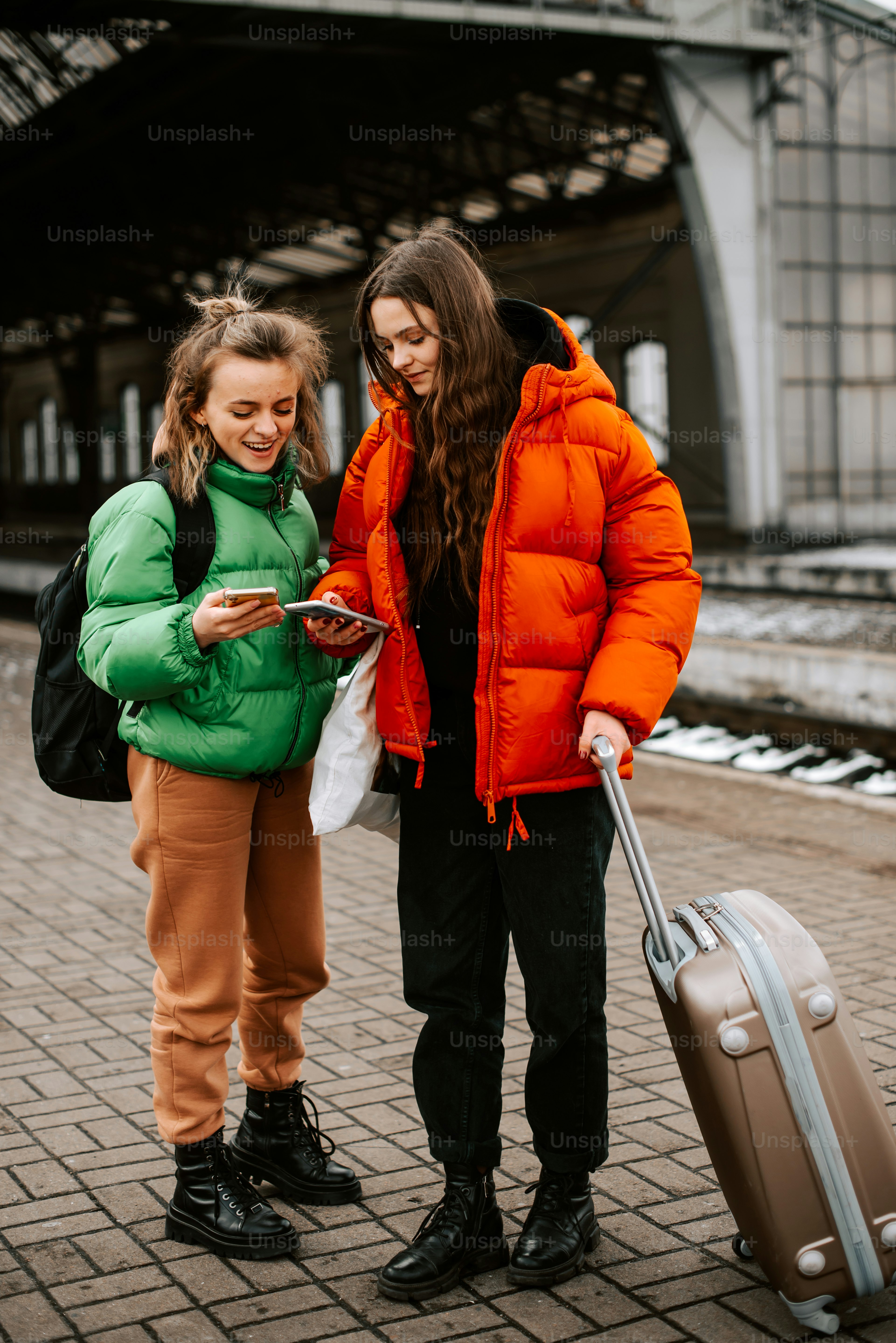 two women standing next to each other with luggage