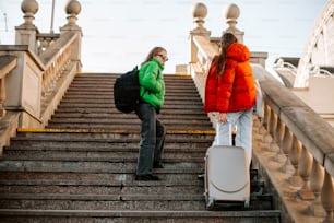 two people walking up a flight of stairs with luggage
