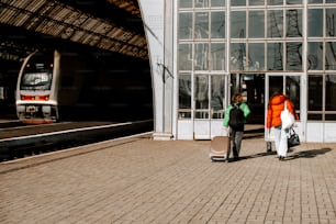 Un par de personas de pie junto a un tren