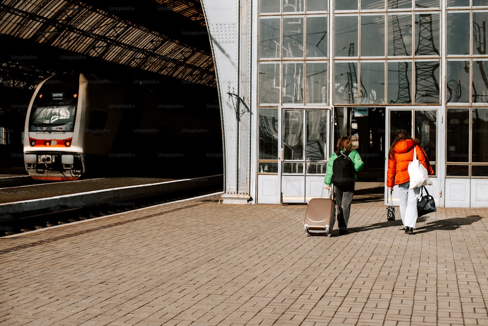 a couple of people standing next to a train