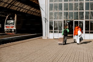 a couple of people standing next to a train