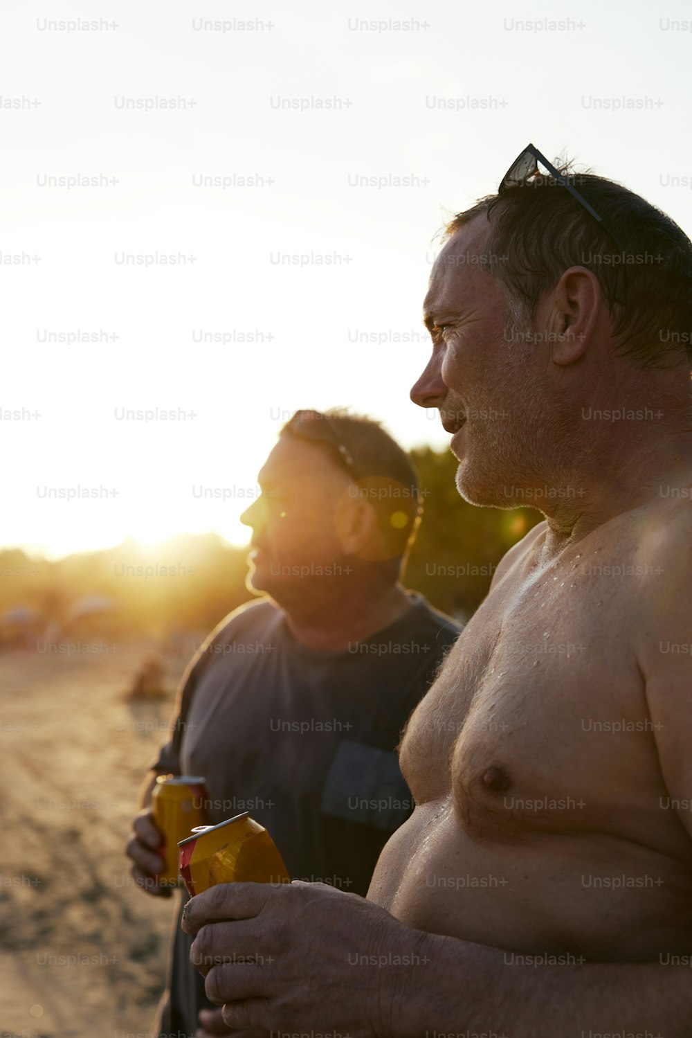 a couple of men standing next to each other on a beach