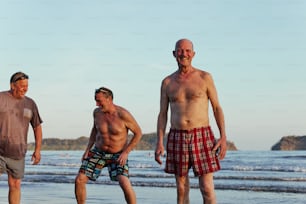 Un gruppo di uomini in piedi sulla cima di una spiaggia vicino all'oceano