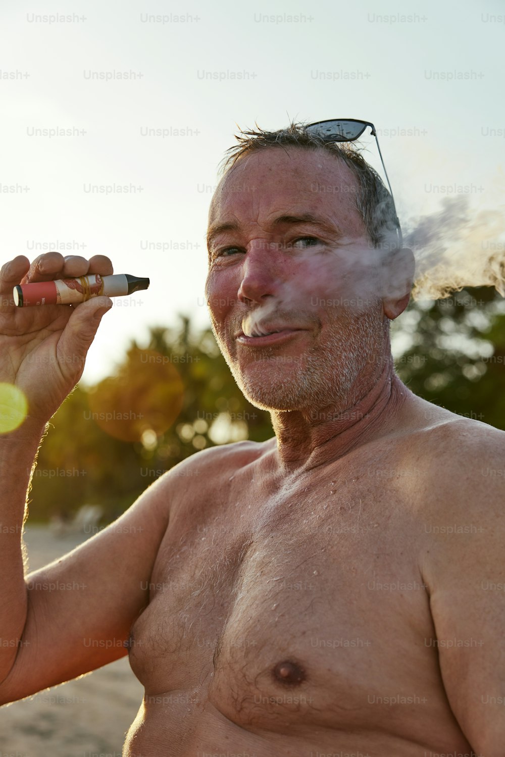 a man smoking a cigarette on the beach