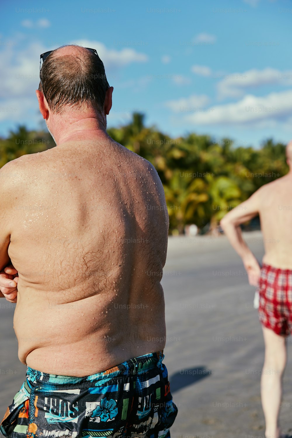 a man walking on a beach next to another man