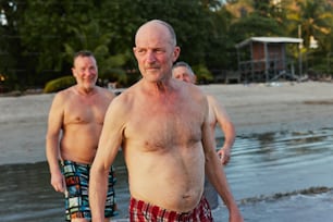 Un uomo senza camicia su una spiaggia accanto a un altro uomo