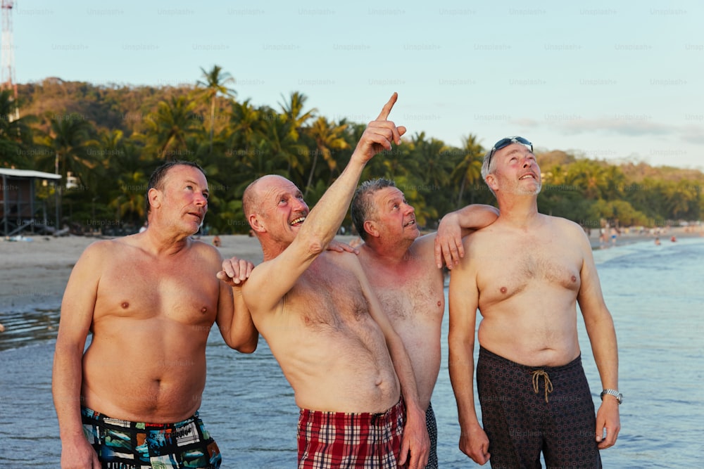 Eine Gruppe von Männern, die nebeneinander am Strand stehen