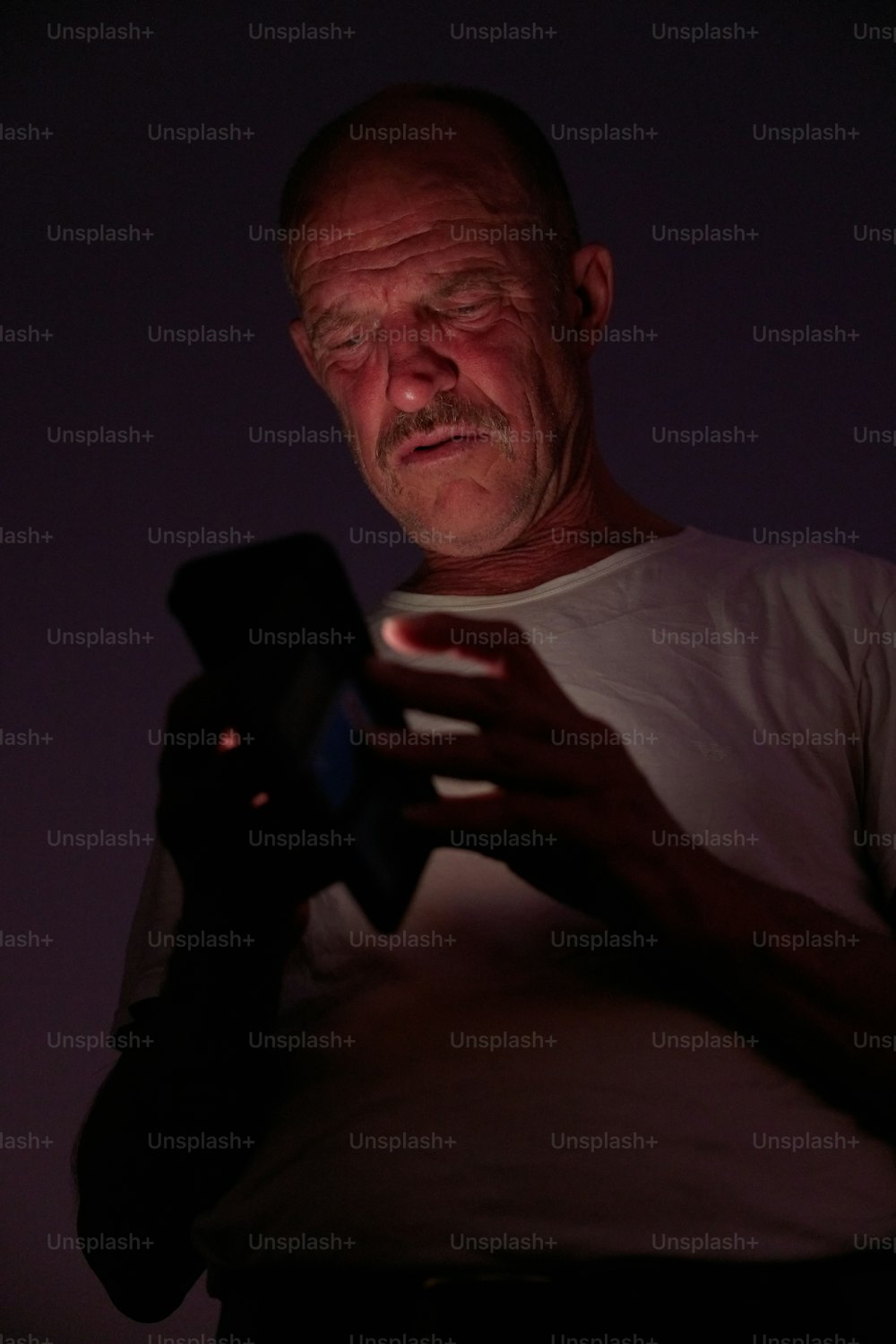 um homem segurando um telefone celular em suas mãos