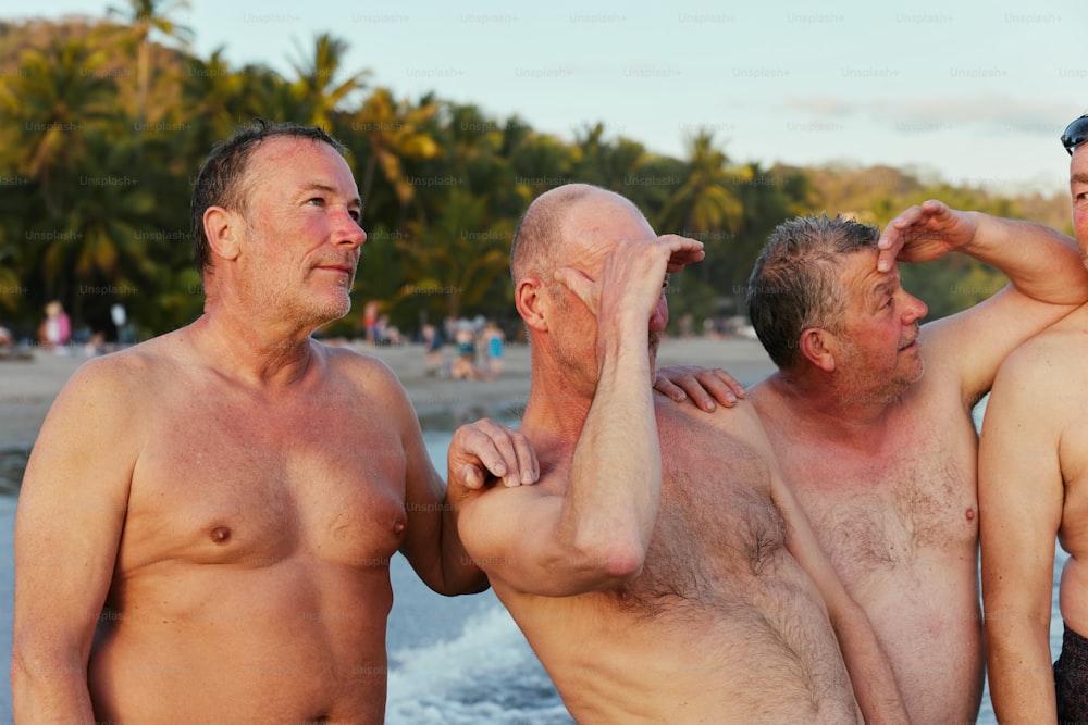 um grupo de homens de pé um ao lado do outro em uma praia