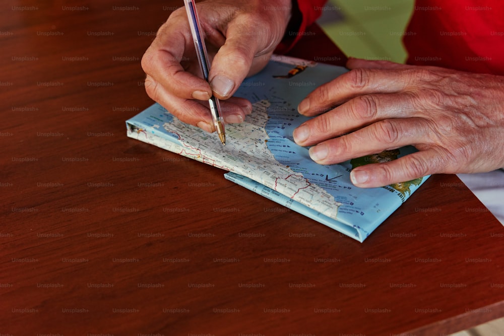 a person writing on a map with a pen