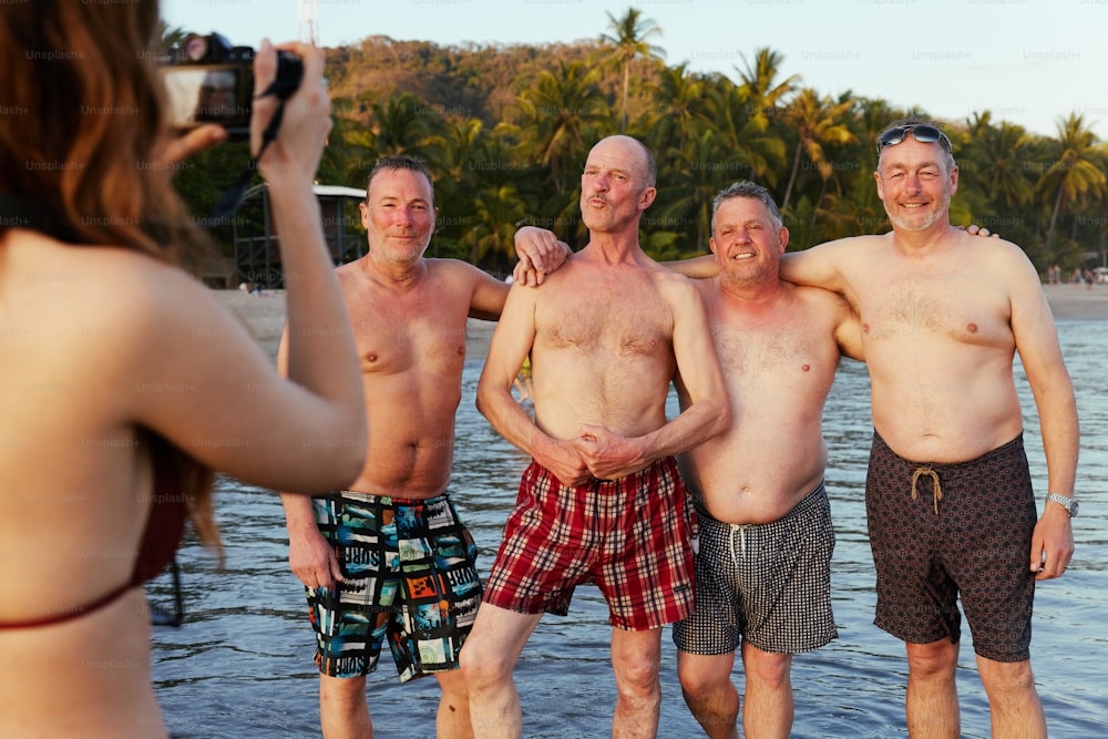 a group of men standing next to each other on a beach