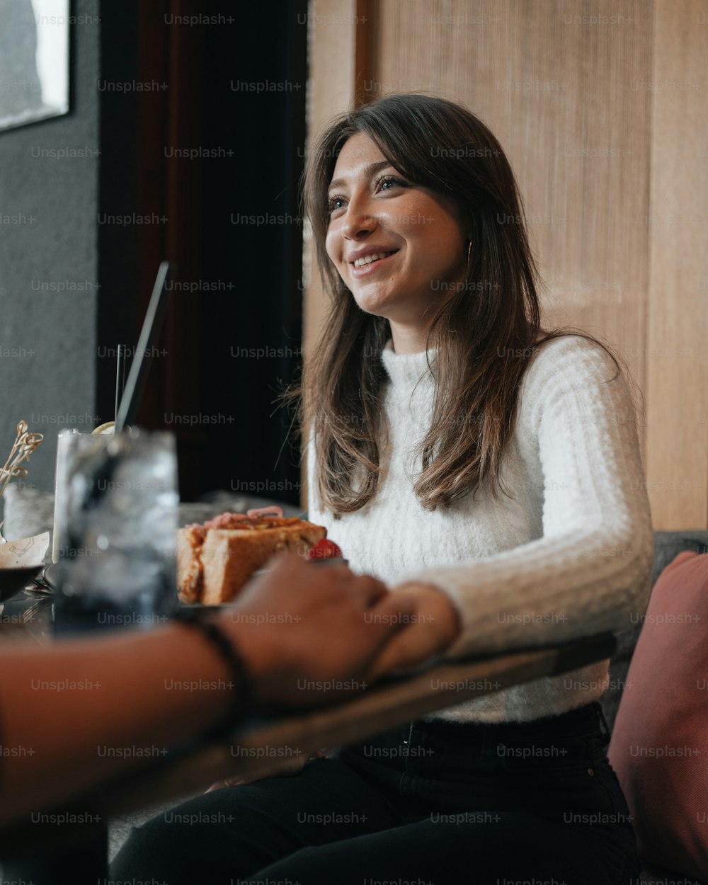a woman sitting at a table with a piece of cake