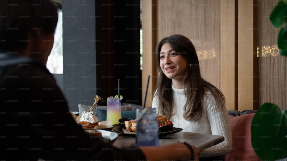 a woman sitting at a table with a plate of food