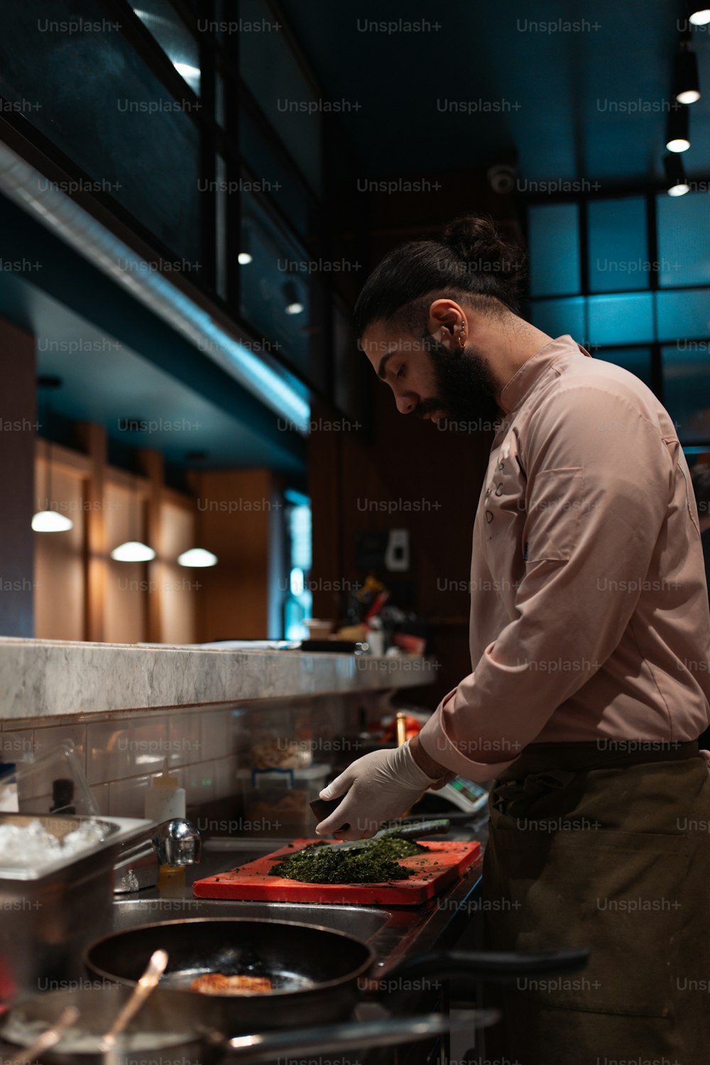 um homem em pé em uma cozinha preparando comida