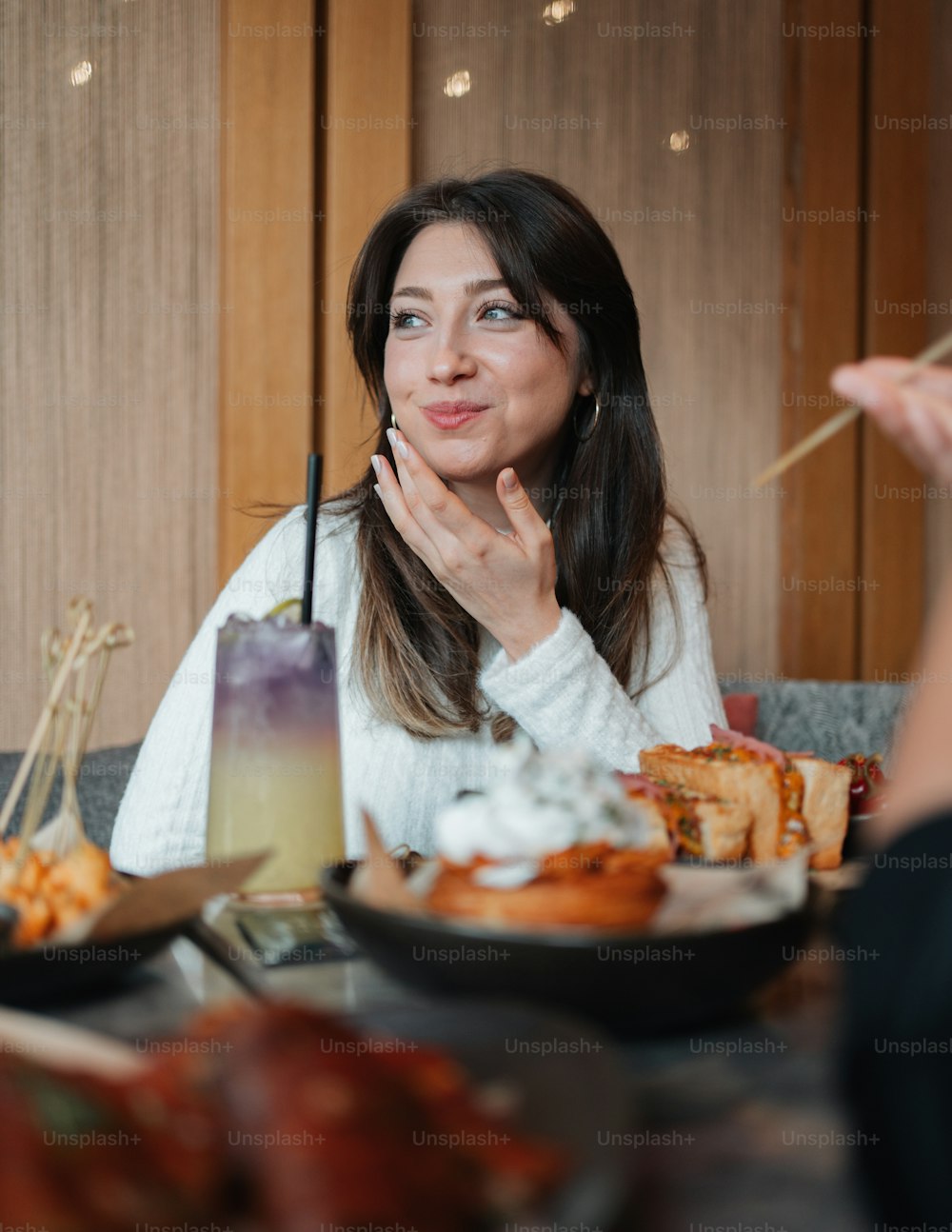 음식 접시가 있는 테이블에 앉아 있는 여자