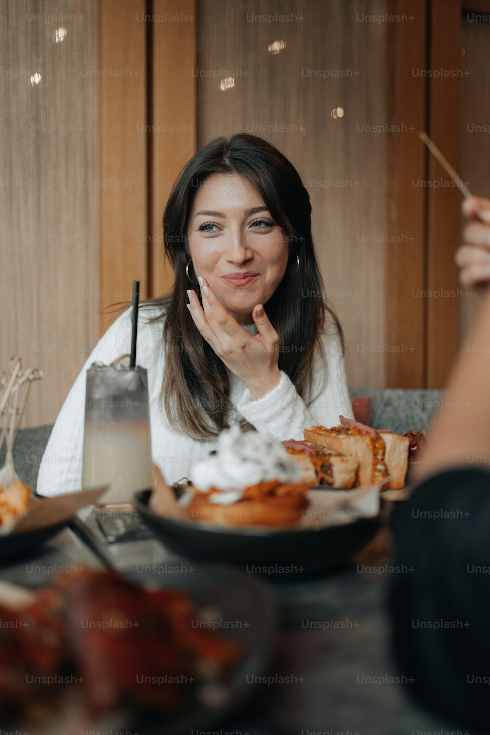 a woman sitting at a table with plates of food